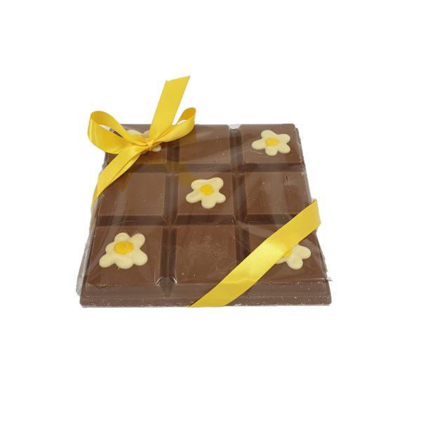 chunky milk chocolate slab with fried egg decoration and yellow ribbon cocoabean