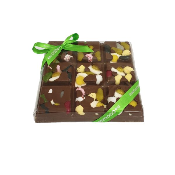 chunky milk chocolate slab with easter themed sweets and green ribbon cocoabean
