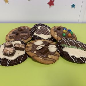 siz decorated cookies on green table