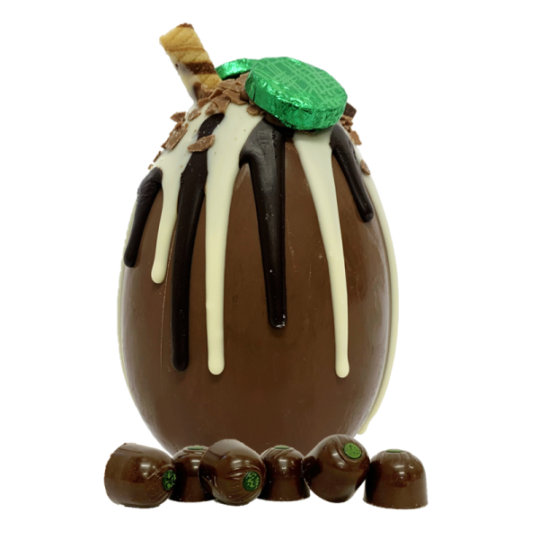 green mint chocolate creams on top a white and dark chocolate drip on top of a milk chocolate easter egg and six milk chocolate creams