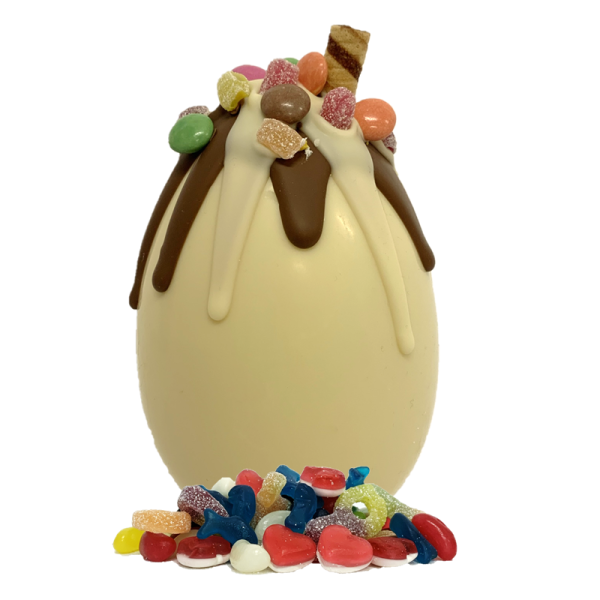 white chocolate easter egg with dripping chocolate and mixed sweets