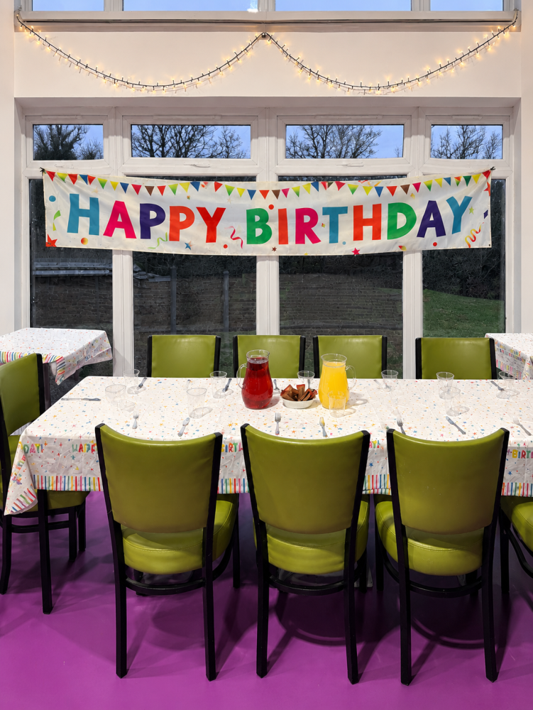 green chairs, birthday party banner and purple floor